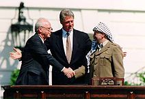 Ицхак Рабин и Ясер Арафат в присутствии президента США Билла Клинтона обмениваются рукопожатием в Вашингтоне на лужайке перед Белым домом