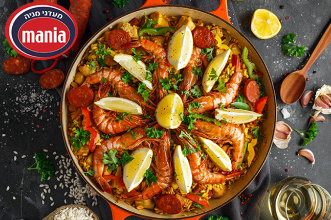 Traditional paella in the fry pan with chicken, prawns, spicy chorizo, lemon and glass of white wine.